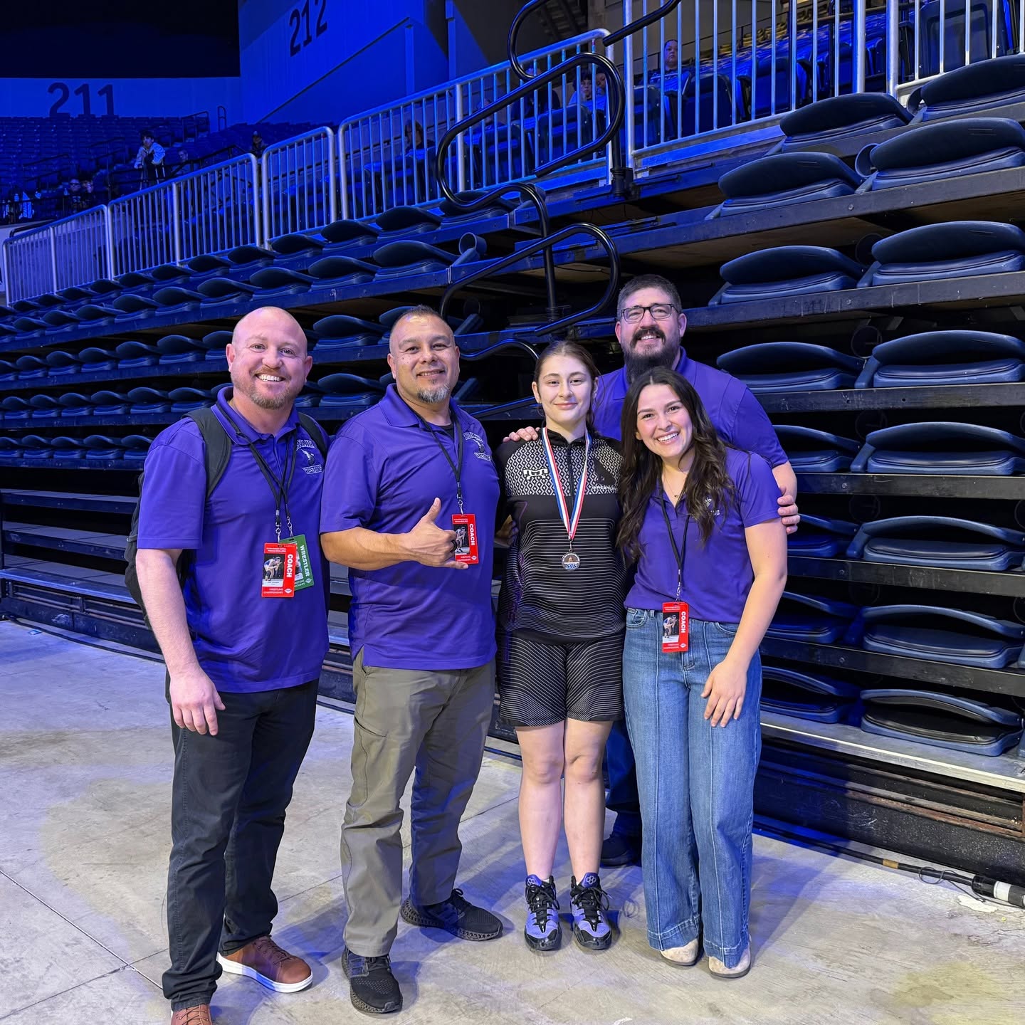 staff standing in front of bleachers